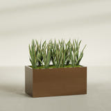 Granada rectangular fiberglass planter in Metallic Bronze, 48 × 24 × 24 in, shown planted in a room