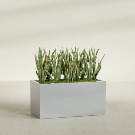 Granada rectangular fiberglass planter in Metallic Silver, 48 × 24 × 24 in, shown planted in a room