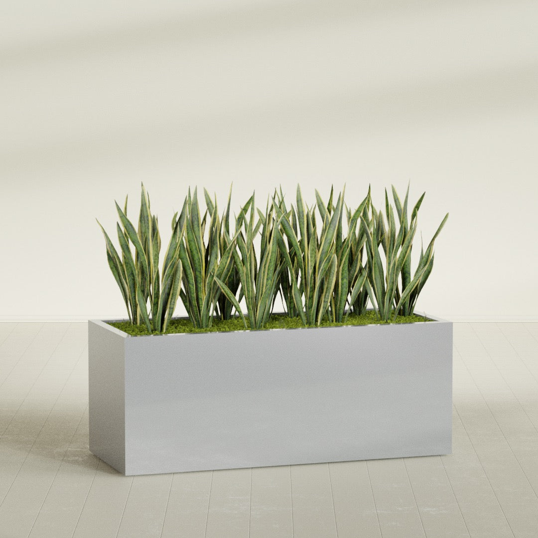 Granada rectangular fiberglass planter in Metallic Silver, 60 × 24 × 24 in, shown planted in a room