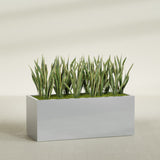 Granada rectangular fiberglass planter in Metallic Silver, 60 × 24 × 24 in, shown planted in a room
