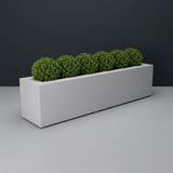 Salon Box fiberglass planter in Matte Bright White, planted with row of small clipped boxwood balls, studio