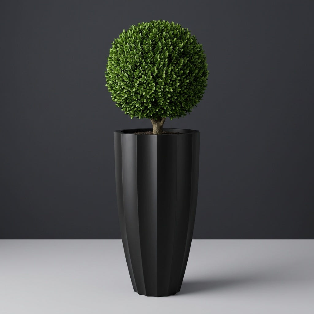San Jose Tall Fluted fiberglass planter in Matte Black, planted with clipped boxwood ball on a short trunk, studio